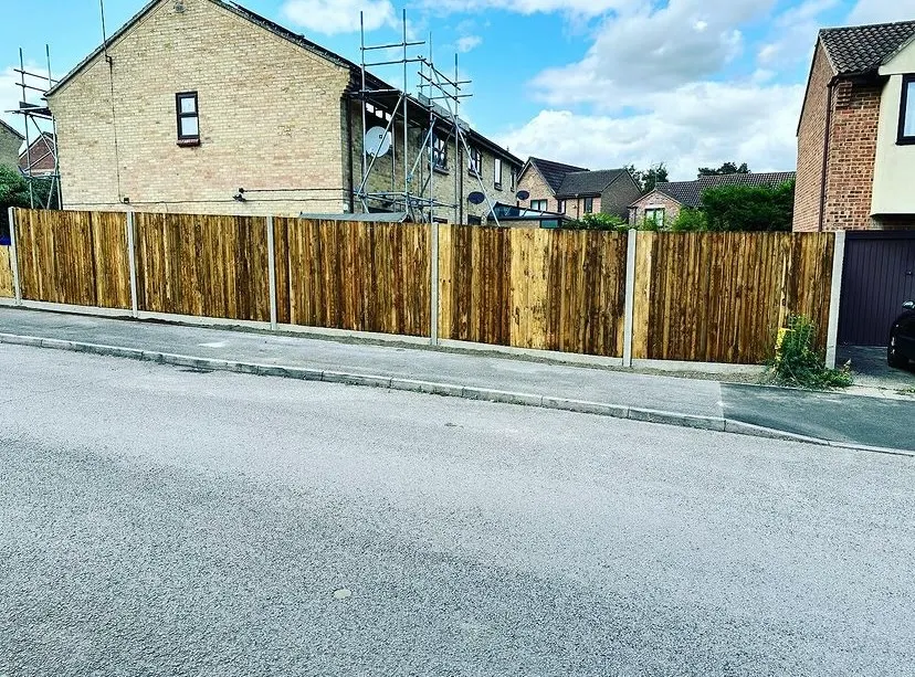 Dark stained garden fence panels with decorative toppers