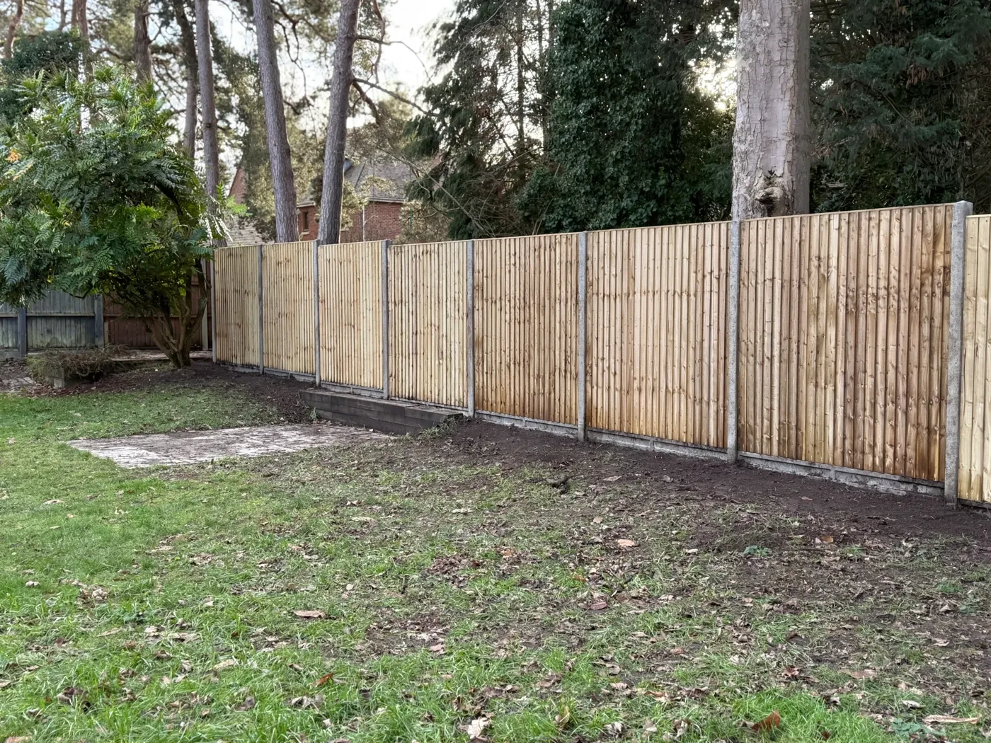 Long closeboard boundary fence running across a large garden