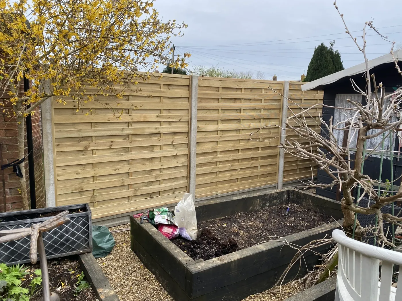 Completed garden fencing project with woven horizontal panels