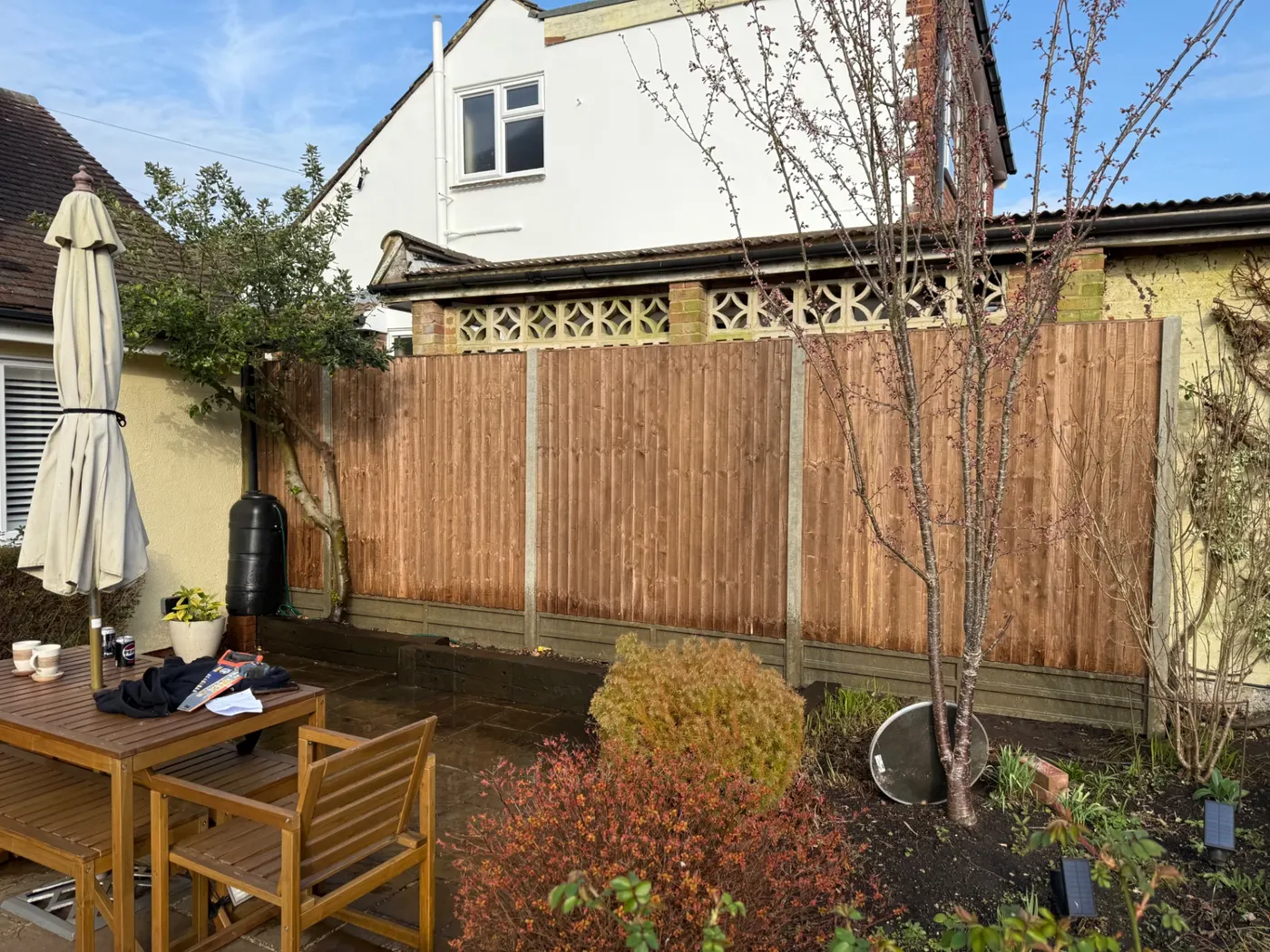 Brown feather edge fence panels behind a garden patio