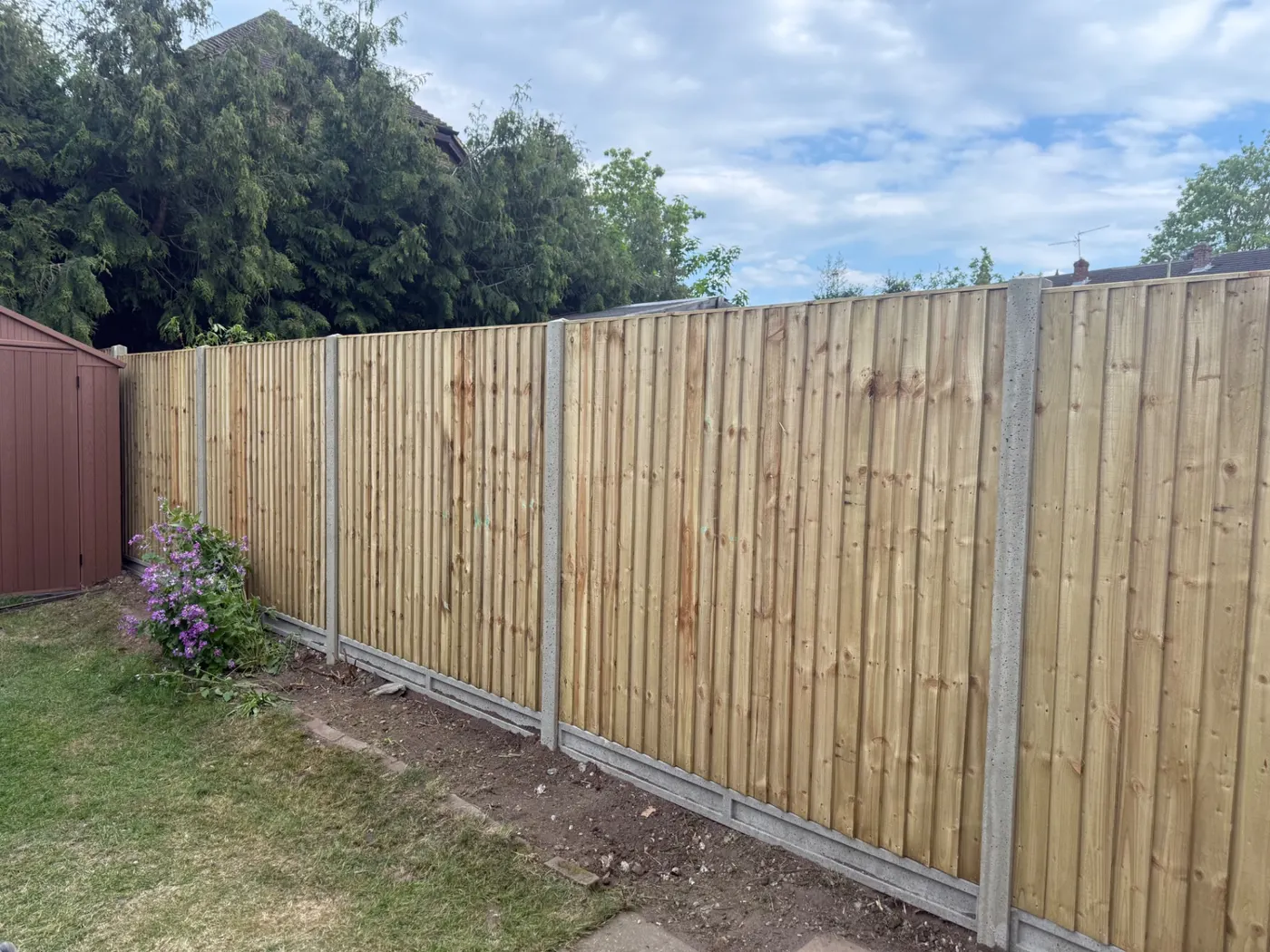 Long run of closeboard fence panels with gravel boards