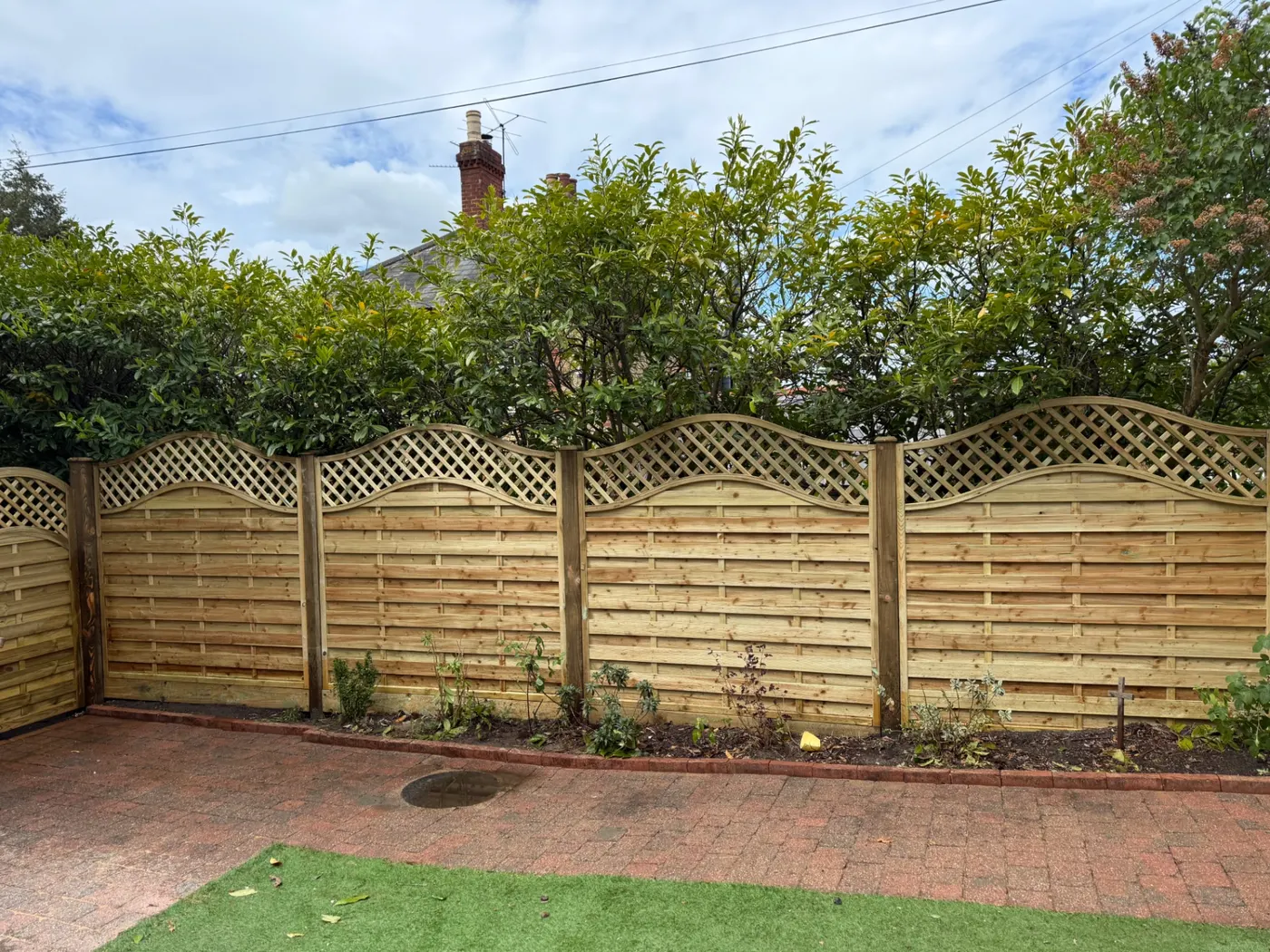 Trellis topped garden fence panels along a back garden boundary