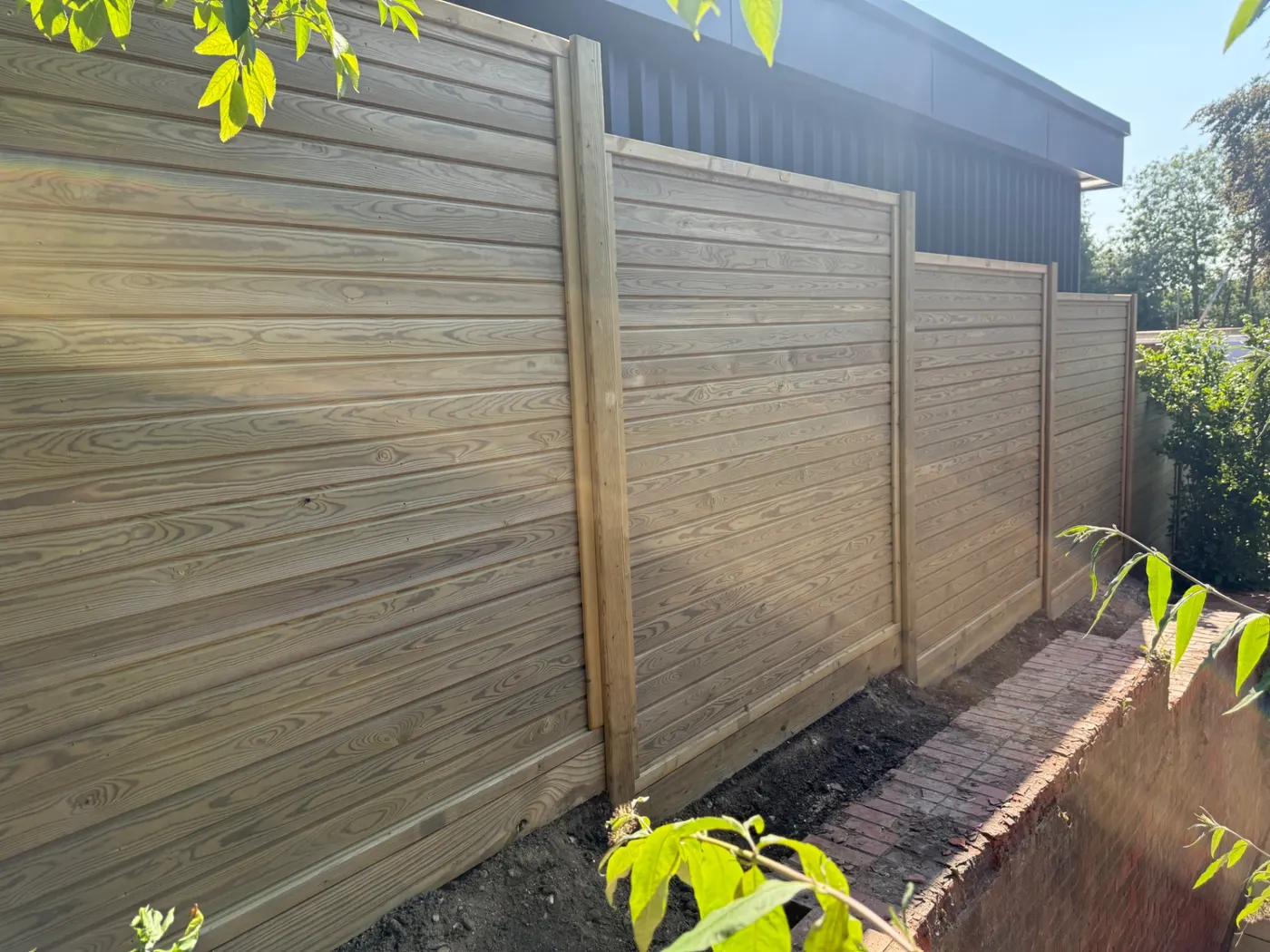 Horizontal tongue and groove fence panels in a landscaped garden