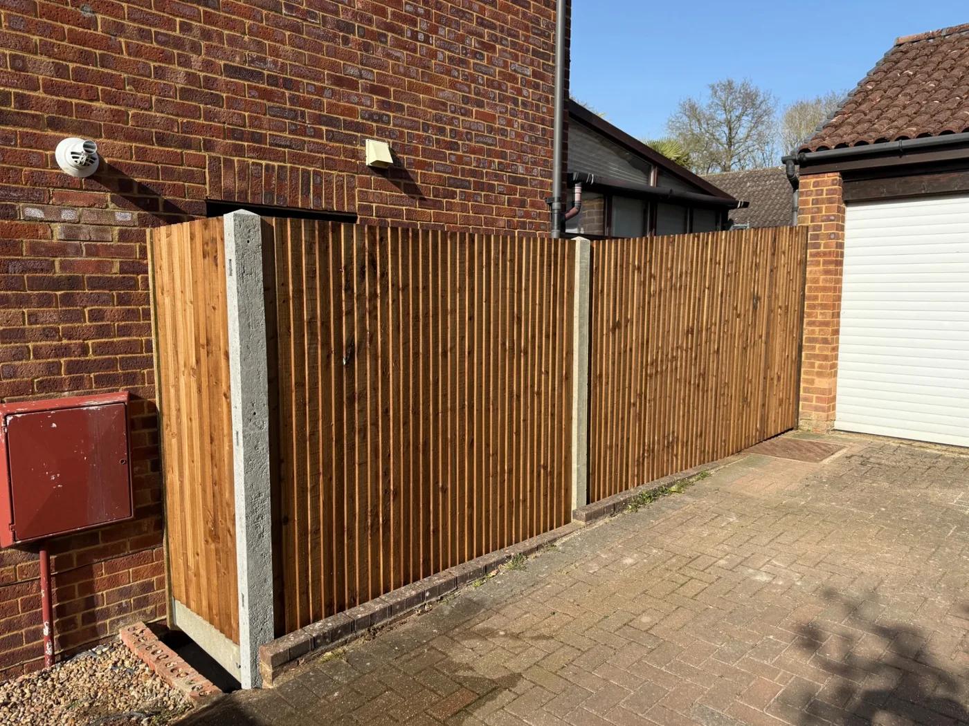 Closeboard fencing screening a driveway next to a garage