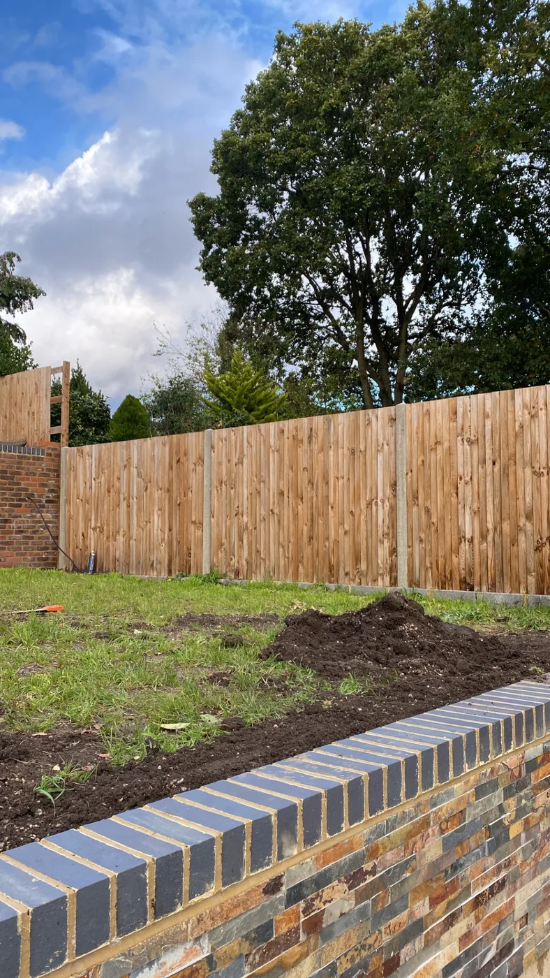New closeboard fence panels fitted above a brick garden wall