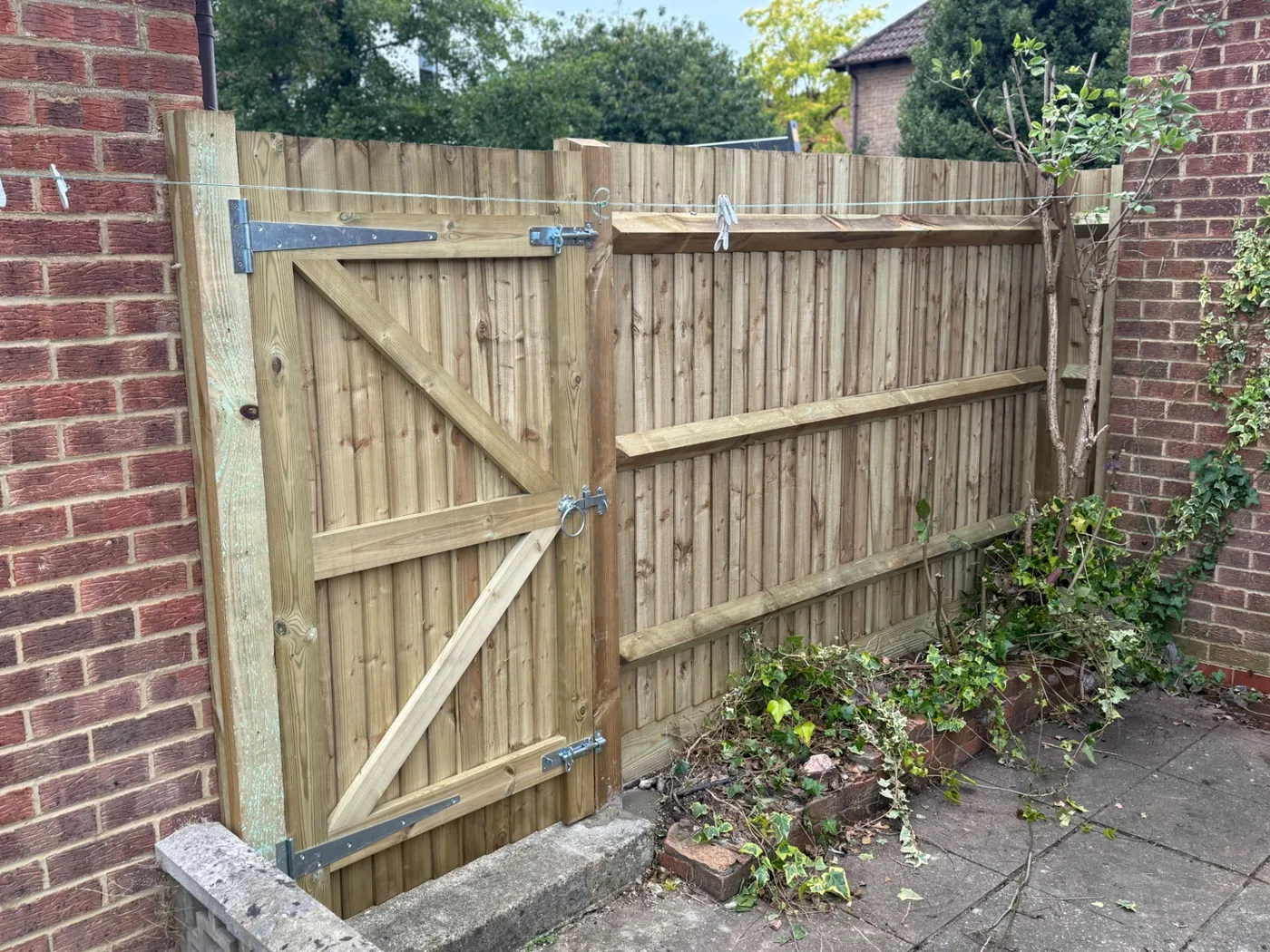 Braced closeboard side gate hung between brick walls