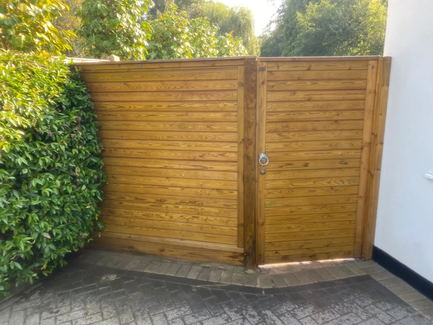 Wide horizontal board driveway gates hung on heavy posts