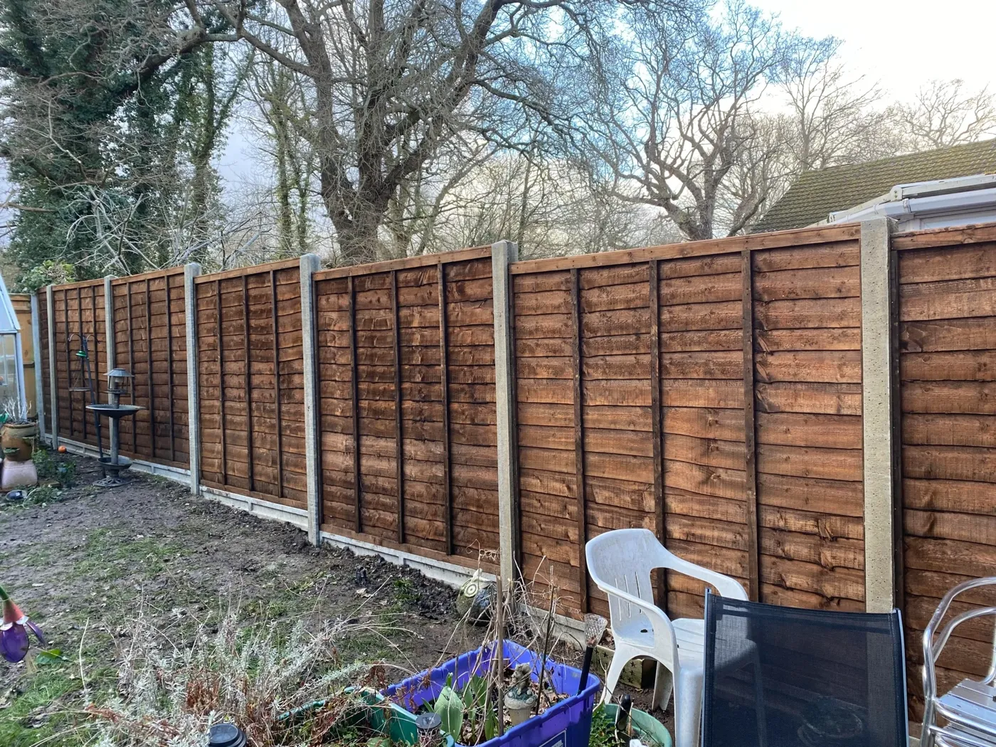 New garden fence with concrete posts along a lawn edge